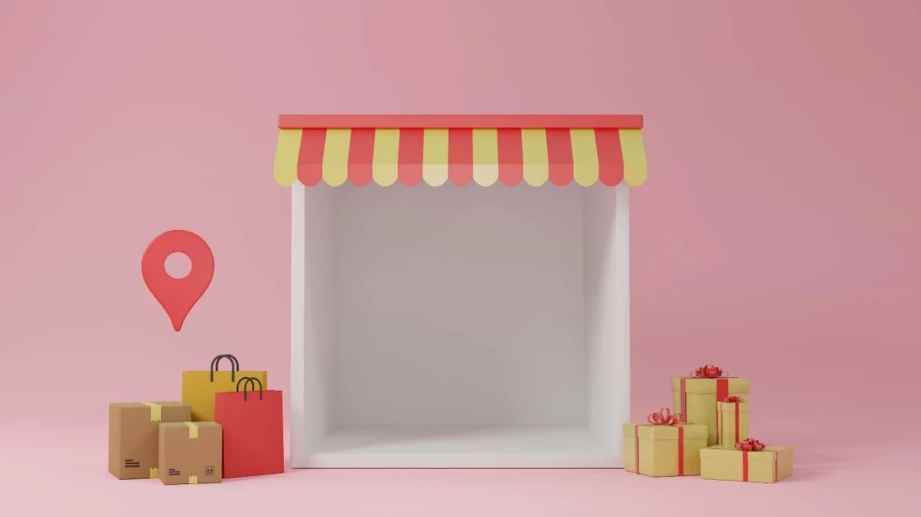 Representation of store front on pink background with gift boxes and shopping bags out the front.