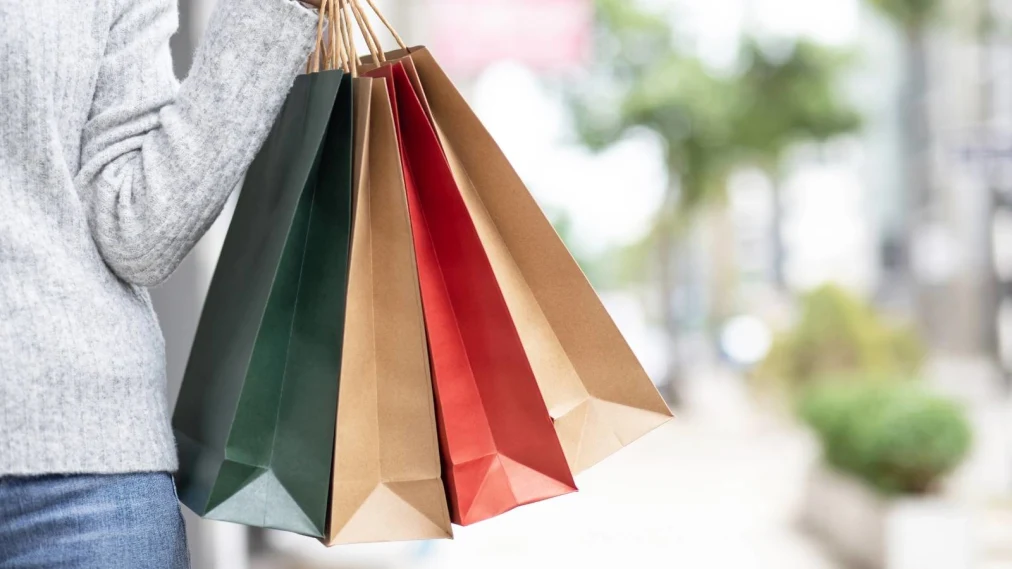 Person holding colourful paper shopping bags