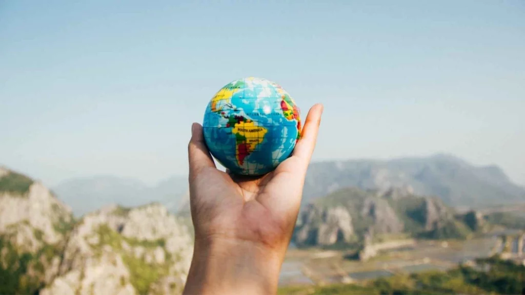 Hand outstretched holding a mini globe