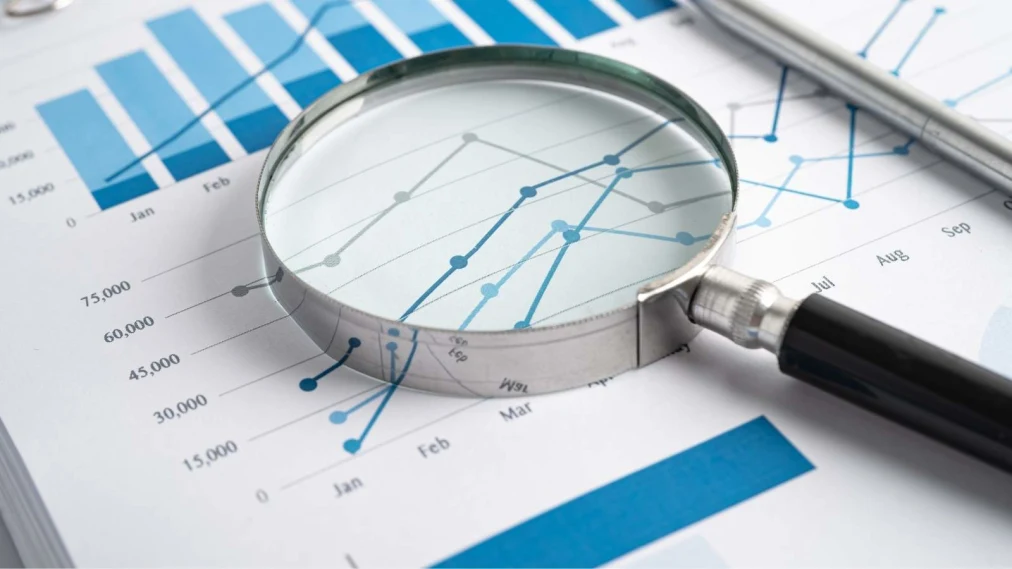 Magnifying glass on a line chart on paper.