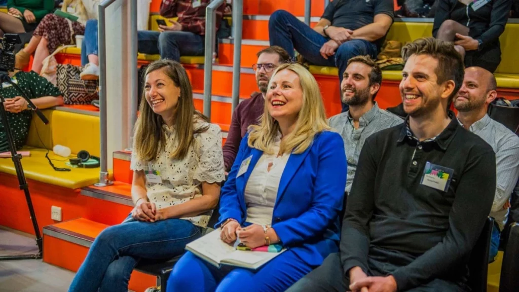 Jaye, Michael and Marion sat at an event on the front row laughing.