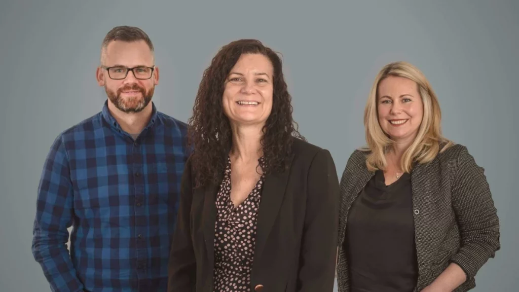 Three Launch Key Team Members stood in front of grey background. Mike, Steph and Jaye (left to right).