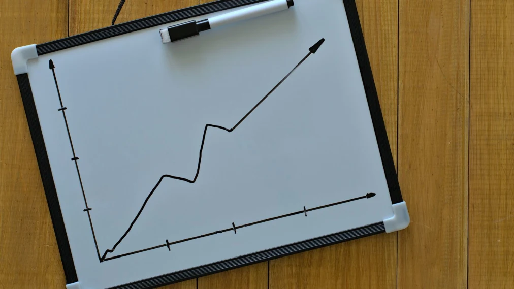 Whiteboard with upwards graph arrow drawn on.