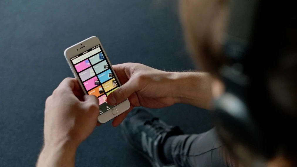 Person holding a phone, looking at Spotify