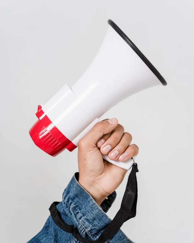 Hand holding a white megaphone