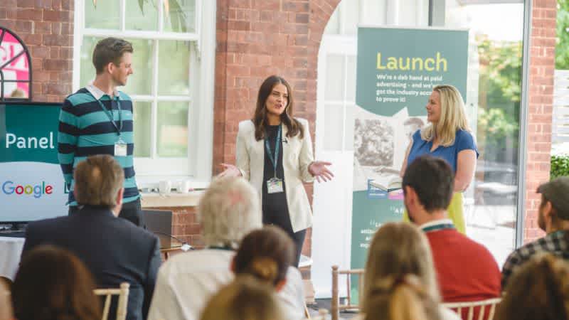 Exeter event image. Three Launch team members stood in front of crowd giving a presentation.