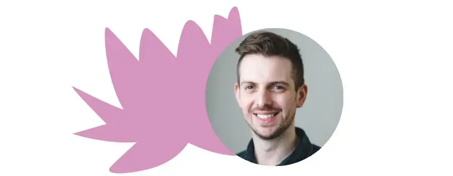 Man with dark hair and stubble, smiling, in a circle frame with a pink flower detail