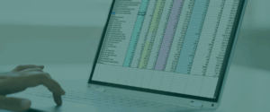 Image is decorative, shows a laptop screen with a spreadsheet on it