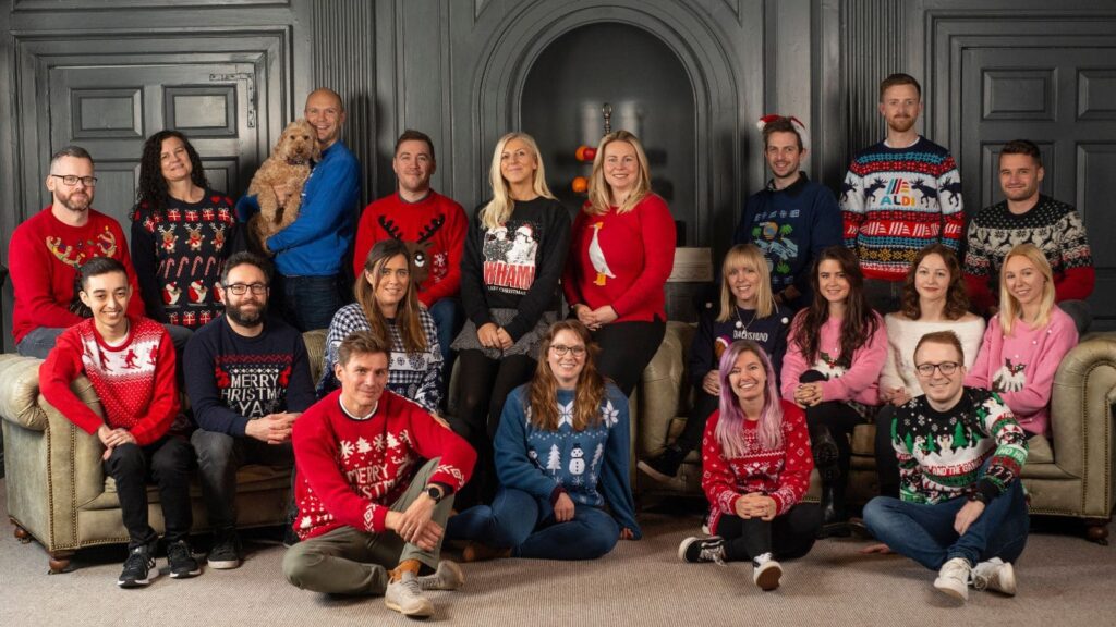The Launch team wearing Christmas jumpers and sat on sofas