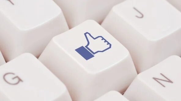 Computer keyboard close up with Facebook Like Thumbs up on a key